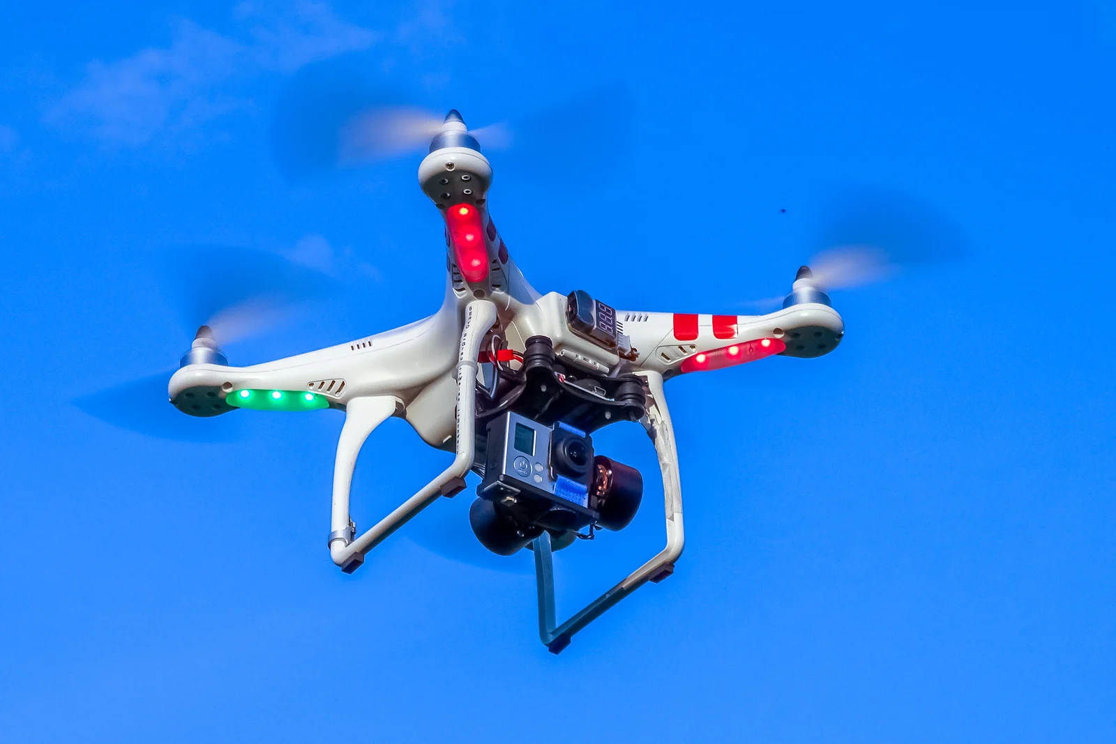 A period DJI Phantom quadcopter with red arm markings flying outdoors